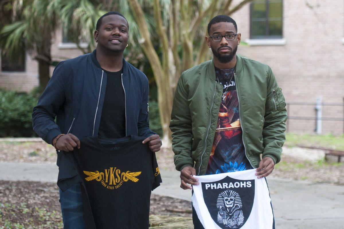 International trade and finance senior Travis Mamon (left) and general business senior Ottis Johnson (right) pose on Wednesday, Jan. 27, 2016, with clothing brand Young Kings Society merchandise.