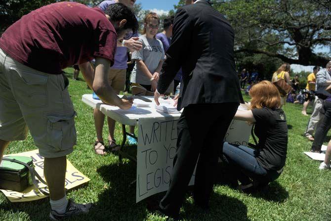 Protestors write letters to the legislative before the March the Captiol protest Thursday, Apr. 30, 2015 at A.Z. Young Park in downtown Baton Rouge. The protest was held in response to the Louisiana higher education budget cuts.