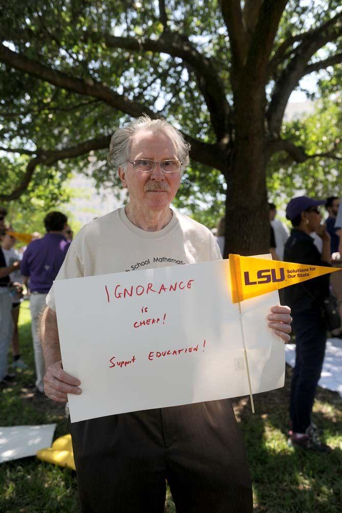 LSU mathematics professor Robert Perlis holds up a sign at the March the Capitol protest Thursday, Apr. 30, 2015 to protest higher education budget cuts.