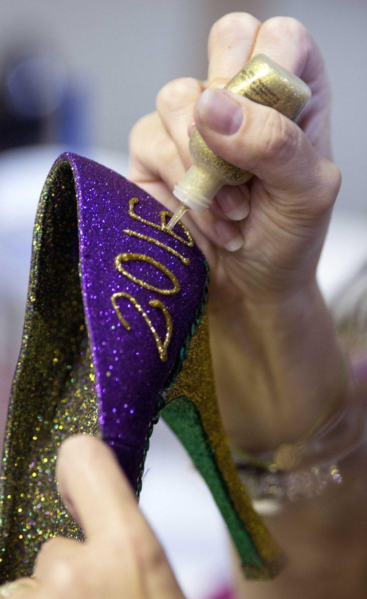 Cari Rhoton, a lieutenant in an all-female Mardi Gras parade group known as the Krewe of Muses, creates one of the group's signature shoes from her garage in Kenner, La., Sunday, Jan. 10, 2016. Over 1000 members of the organization ride floats and pass out hand decorated shoes and other trinkets during Mardi Gras. (AP Photo/Max Becherer)