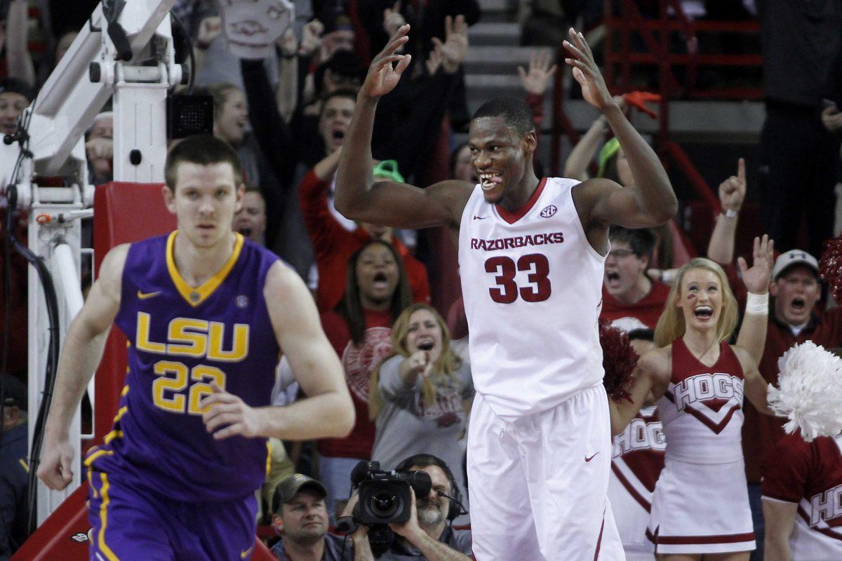 LSU's Darcy Malone (22) hustles back as Arkansas' Moses Kingsley (33) celebrates a dunk during the second half of an NCAA college basketball game Tuesday, Feb. 23, 2016, in Fayetteville, Ark. Arkansas won 85-65. (AP Photo/Samantha Baker)