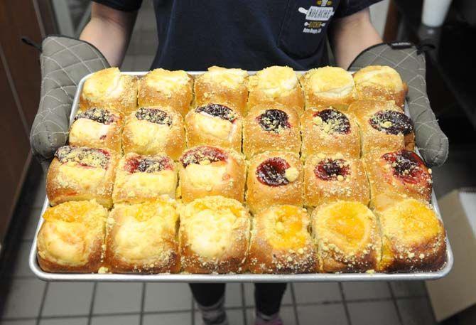 A Kolache Kitchen employee holds a tray of baked fruit kolaches Monday, Jan. 12, 2014 before putting them in the warmer.