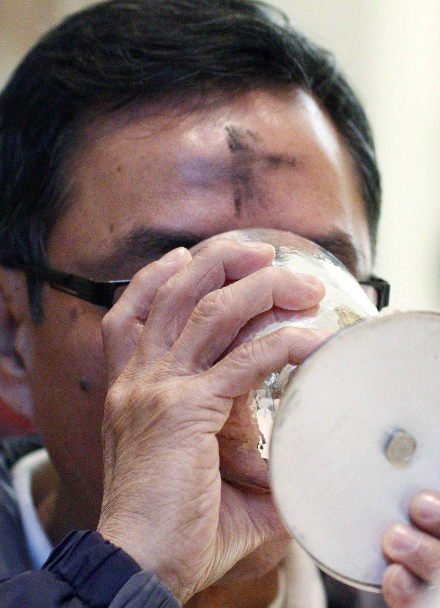 An ash covered celebrant drinks from a chalice during Communion at a Ash Wednesday service at The Cathedral of Saint Peter the Apostle in Jackson, Miss., on Wednesday, Feb. 10, 2016. Ash Wednesday marks the beginning of the 40 days of Lent. (AP Photo/Rogelio V. Solis)