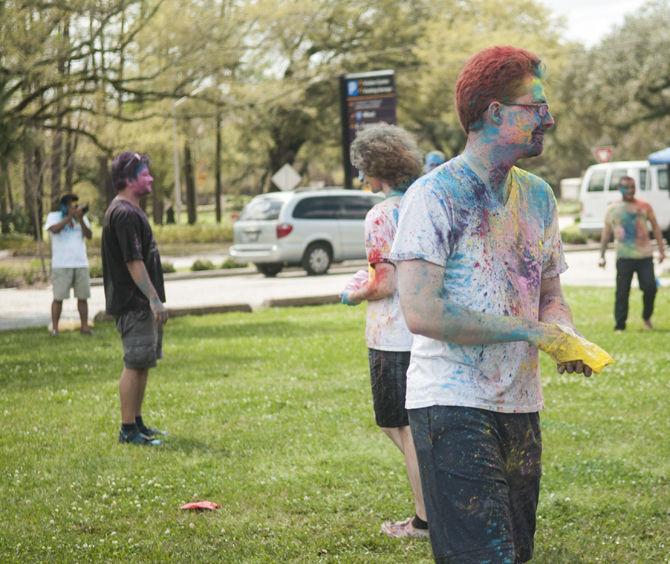 Students throw colored dye to celebrate Holi festival