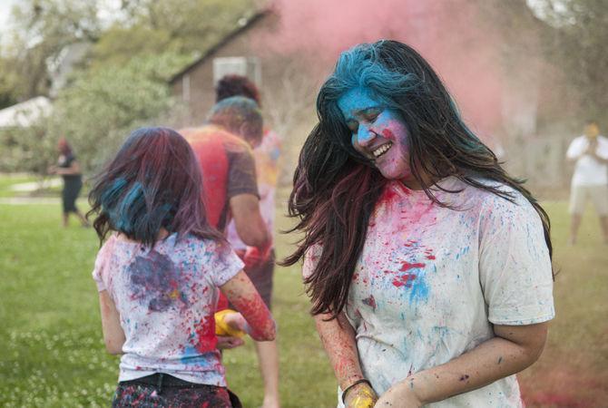 Students throw colored dye to celebrate Holi festival