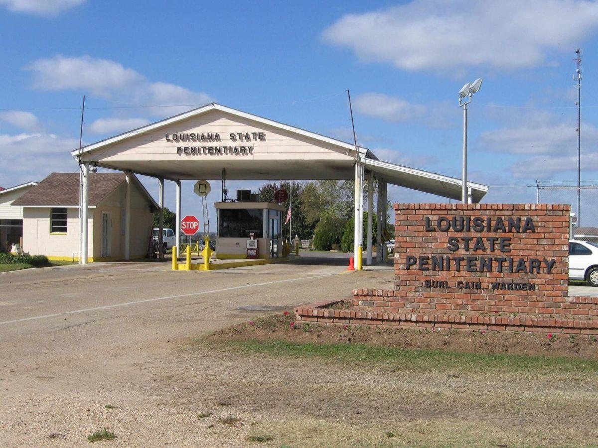 The front gates of Louisiana State Penitentiary stand below passing clouds in Angola, LA.