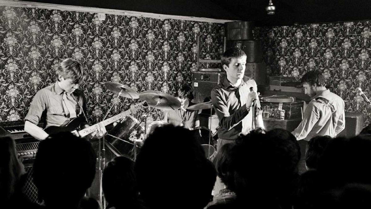 Joy Division playing live infront of fans and some rad wallpaper.