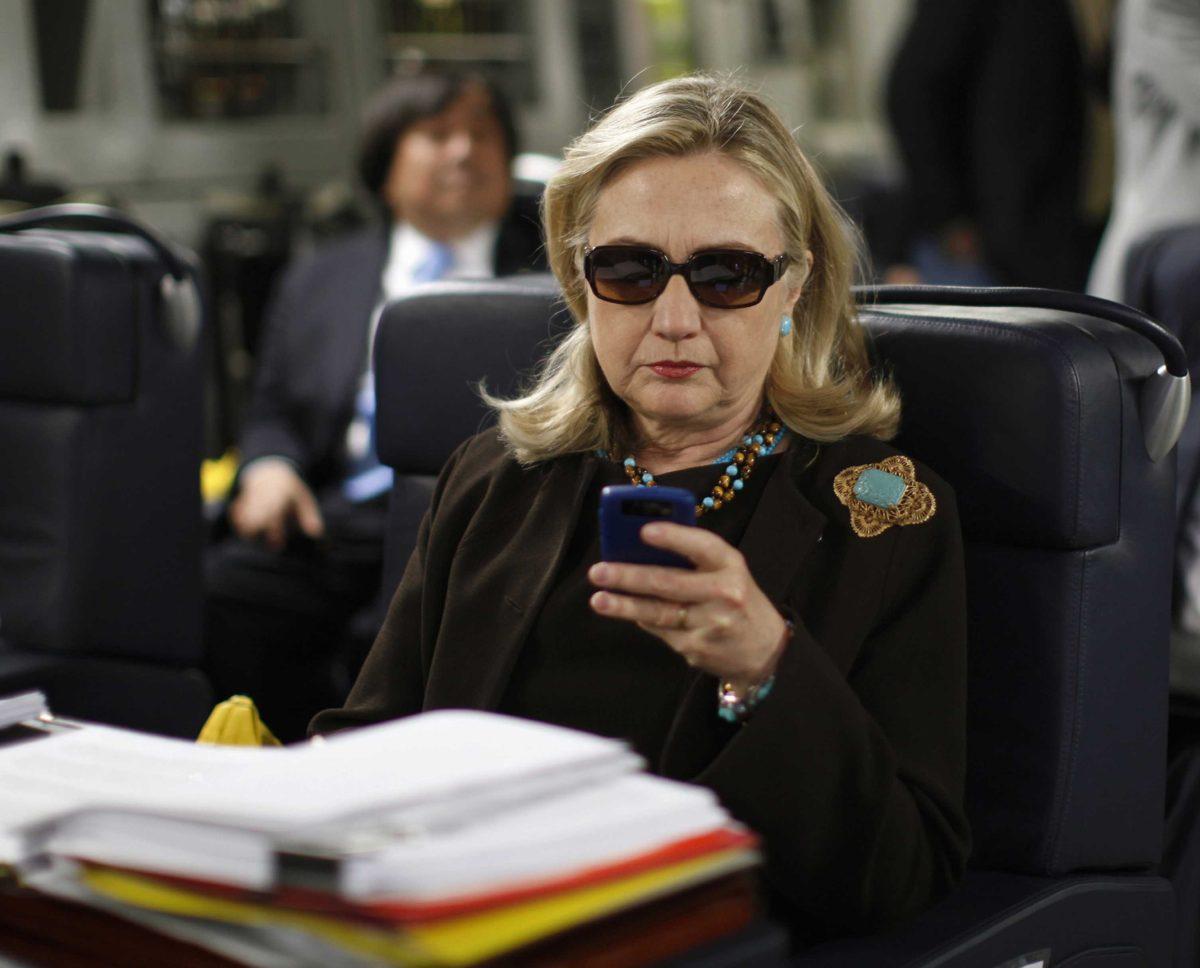 FILE - In this Oct. 18, 2011, file photo, then-Secretary of State Hillary Rodham Clinton checks her Blackberry from a desk inside a C-17 military plane upon her departure from Malta, in the Mediterranean Sea, bound for Tripoli, Libya. Newly released emails show a 2009 request to issue a secure government smartphone to then-Secretary of State Hillary Clinton was denied by the National Security Agency. (AP Photo/Kevin Lamarque, Pool, File)