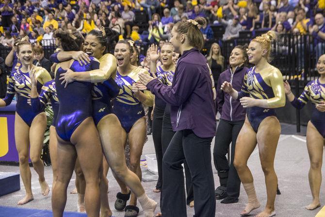 LSU junior Ashleigh Gnat is congratulated by senior all-around Jessica Savona and the rest of her teammates after her beam rutine during the Tigers' 197.825-197.125 victory against Auburn on Friday, Feb. 19, 2016 in the PMAC.