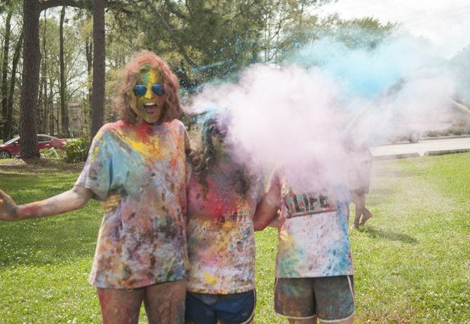 Students throw colored dye to celebrate Holi festival