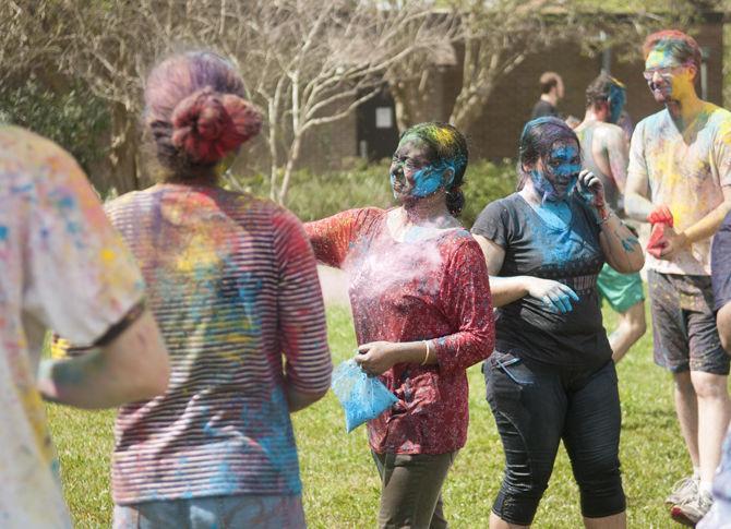 Students throw colored dye to celebrate Holi festival