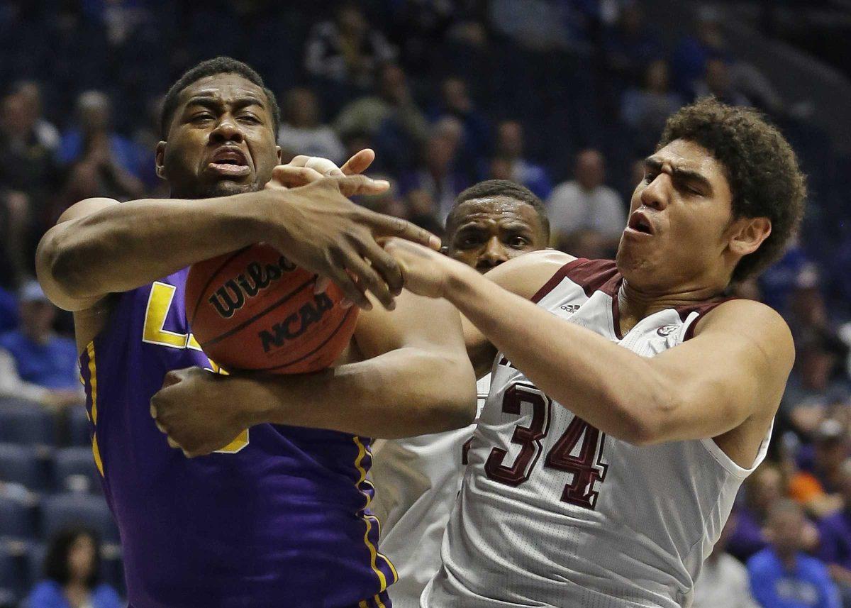 Texas A&amp;M's Tyler Davis, right, and LSU's Elbert Robinson III, left, battle for a rebound during the first half of an NCAA college basketball game in the Southeastern Conference tournament in Nashville, Tenn., Saturday, March 12, 2016. (AP Photo/Mark Humphrey)