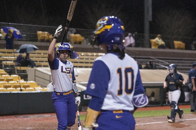 LSU seinor catcher Kellsi Kloss (77) tosses the bat towards sophomore infielder Sydney Bourg (10) during game two of the Tigers' 1-0 victory against Longwood University on Tuesday, Mar. 8, 2016 in Tiger Park.