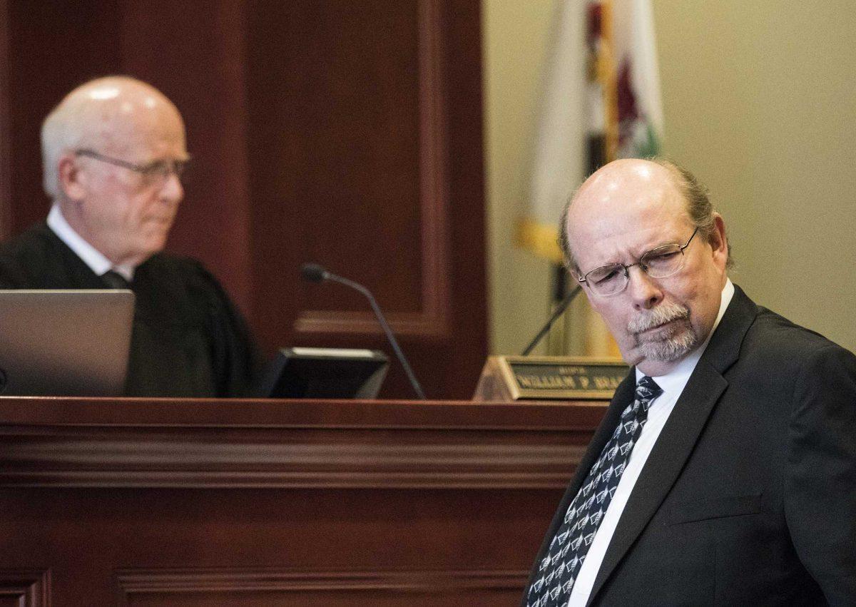 DeKalb County State's Attorney Richard Schmack looks back into the courtroom on Friday, April 1, 2016, in Sycamore, Ill., during a hearing in the murder case of Jack McCullough. McCullough was convicted in 2012 for the 1957 killing of 7-year-old Maria Ridulph, of Sycamore. McCullough's attorneys Gabriel Fuentes and Shaun Van Horn filed a motion Thursday requesting DeKalb County Judge William Brady, left, to vacate their client's murder conviction or release him on bond. Brady denied both motions. McCullough's lawyers filed the motion, citing a report from Schmack that concluded old files and some new evidence demonstrated McCullough couldn't possibly have killed Ridulph. (Danielle Guerra/Daily Chronicle via AP) MANDATORY CREDIT; CHICAGO TRIBUNE OUT