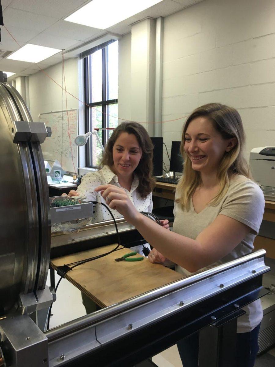 Second-year PhD student Erin Good and her adviser, physics assistant professor Catherine Deibel, look at one of Good's detectors Tuesday, April 26.