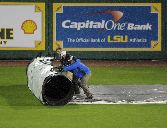 The LSU Tarp Crew rolls out the infield tarp Tuesday, Feb. 25, 2014 in Alex Box Stadium. After more than an hour of rain delay, ULL was declared the winner over LSU by a score of 4-1.