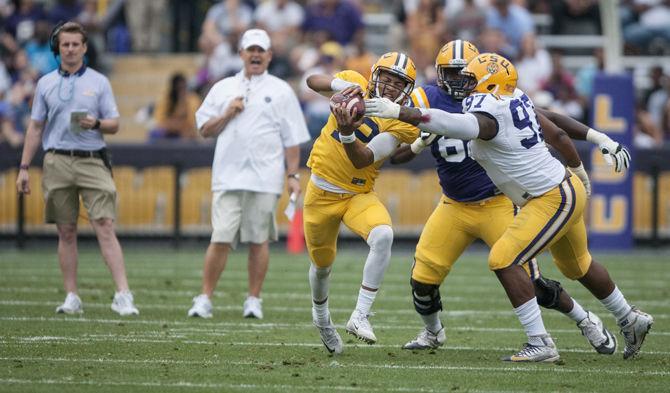 LSU freshman quarterback Justin McMillan (12) struggles to keep the ball during the Tigers' Purple Team 17-7 victory against the Gold Team on Saturday, April 16, 2016 in Tiger Stadium.