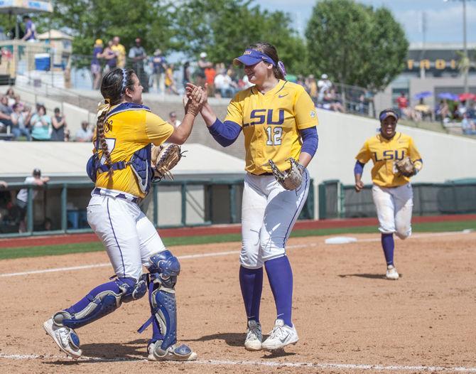 LSU senior catcher Kellsi Kloss (77) high-fives freshman pitcher Sydney Smith (12) after the Tigers' 2-0 victory against South Carolina on Sunday, Apr. 24, 2016 in Tiger Park.