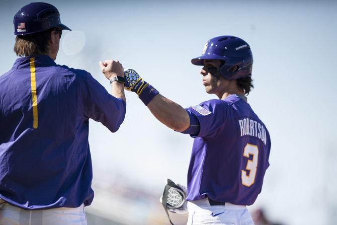 LSU junior infielder Kramer Robertson (3) is congratulated after successfully running to first base on Saturday, March 5, 2016, during the Tigers' 15-1 win against Fordham at Alex Box Stadium.