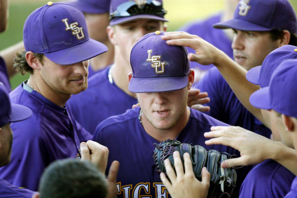 LSU pitcher Jared Poche' is greeted at the dugout after finishing the eighth inning of an NCAA college baseball tournament regional game against Rice in Baton Rouge, La., Tuesday, June 7, 2016. LSU won 5-2 to advance to the Super Regionals. (AP Photo/Gerald Herbert)