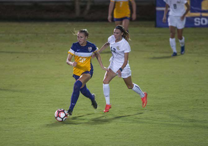 LSU freshman defender Marlena Cutura (20) runs the ball against George Washington University senior forward MacKenzie Cowley during Tigers 1-3 loss onThursday Aug. 25, 2016.