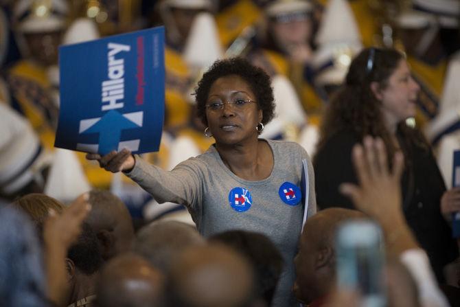 A supporter of democratic Presidential candidate Hillary Clinton hand out campaign posters to other members of the audience on Monday, Sept. 21, 2015, during a grassroots organizing event in Baton Rouge.