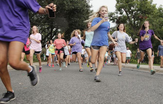 New members run down sorority row to their selected sorority house on Saturday, Aug. 22. 2015 during Bid Day.