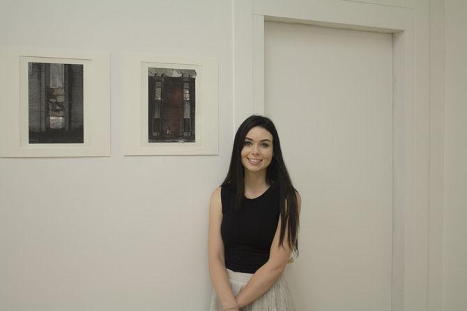 Miram Buckner pleasantly smiles next to a piece in her collection on Tuesday, Aug. 30, 2016 at Gallery 229.