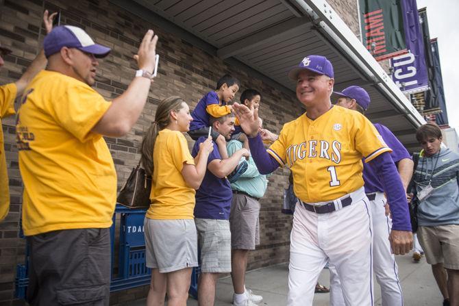 <p>LSU head coach Paul Mainieri is received by LSU fans during the Tigers' entrance to the stadium before the game against TCU in the NCAA Men's College World Series on Thursday, June 18, 2015 at the TD Ameritrade Park in Omaha.</p>