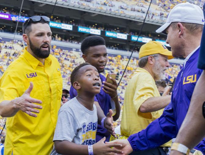 LSU head coach Les Miles shakes a young LSU fan's hand before kickoff on Sept. 17, 2016 at Tiger Stadium.