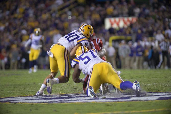 LSU senior linebacker Duke Riley (40) and junior defensive end Davon Godchaux (57) take down an Ole Miss player on Saturday Oct. 22, 2016 during the Tigers' 38-21 victory over the Rebels at Tiger Stadium.