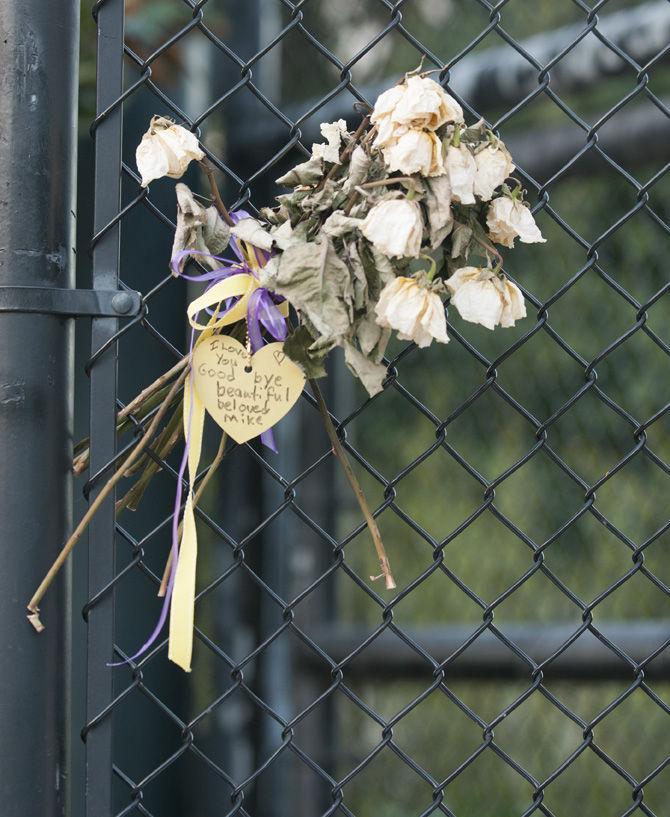 A bouquet of flowers sit with a note reading "I love you, goodbye beautiful beloved Mike."