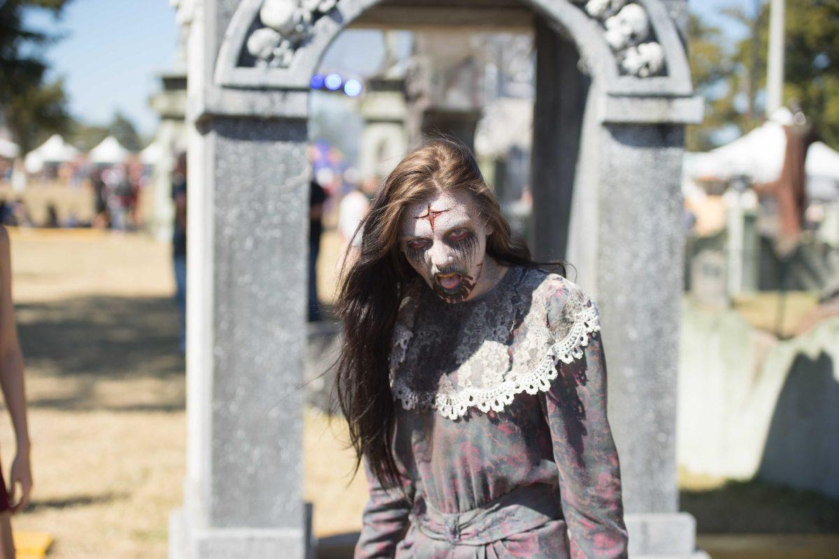 A worker at the interactive cemetery takes a break from chasing festival-goers on Saturday Oct. 29, 2016 at the Voodoo Music and Arts Experience (Voodoo Festival) at City Park in New Orleans, Louisiana.