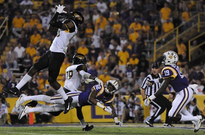 LSU junior wide receiver D.J. Clark (82) is tackled to the ground as Southern Miss defensive back Tarvarius Moore (18) intercepts the ball on Saturday, Oct. 15, 2016, during the Tigers' 45-10 victory against the Golden Eagles in Tiger Stadium.