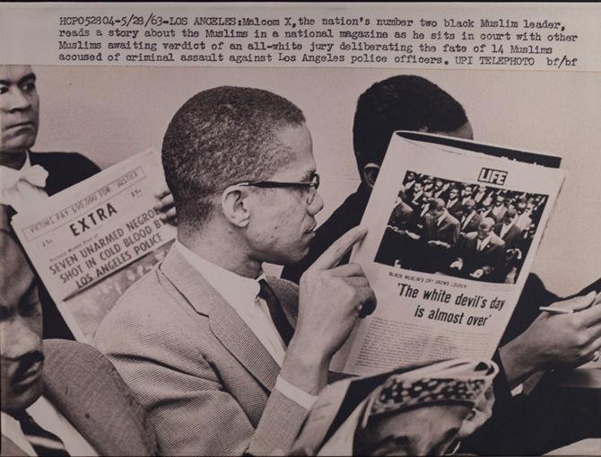 A photo of Malcolm X reading a news article is on display on Nov. 16, 2016, as part of the "For All the World to See: Visual Culture and the Struggle for the Civil Rights" exhibit at the West Baton Rouge Museum in Port Allen.