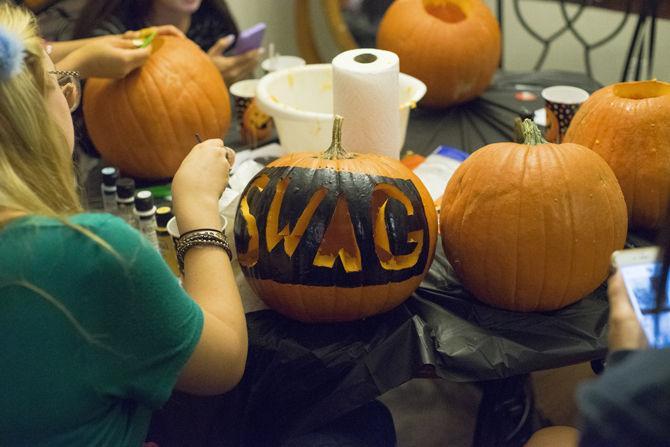 A "swagged out" pumpkin recieves a fresh coat of paint on Oct. 23, 2016 at a Halloween themed get-together.