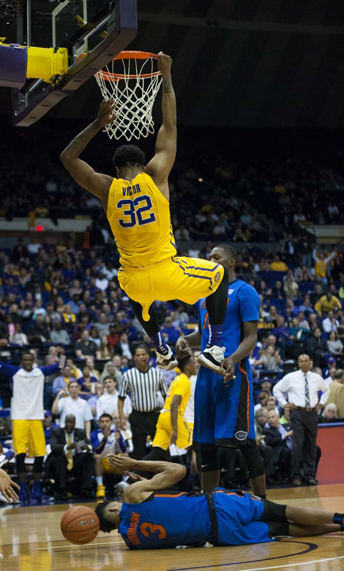 LSU sophomore forward Craig Victor II (32) hangs over a Florida defender after dunking the ball during the LSU 96-91 victory against the Florida Gators on Saturday Feb. 27, 2016, in the PMAC.