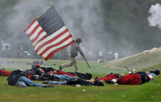 A Confederate soldier retrieves the American Flag Saturday, March 23, 2013 during the reenactment of the seige of Port Hudson at Port Hudson State Historic Site.