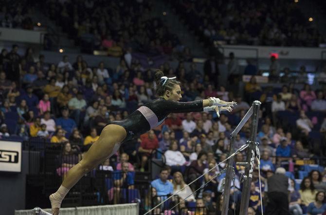 LSU all-around sophomore gymnast Lexie Priessman reaches out to grab one of the uneven bars during the Tigers' 197.475 - 192.625 win over Texas Woman's University on Friday, Jan. 20, 2017 in the Pete Maravich Assembly Center.