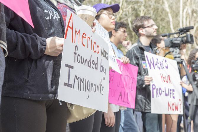 Protesters against President Donald Trump's immigration executive order illustrate their opinions by means of signs and rallying around like-minded speakers on Feb. 1, 2017 in the Quad.