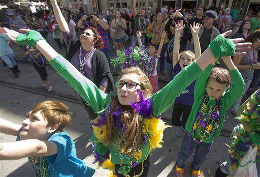 Elycia Cooley, center, and other revelers raise their arms for beads on the first Saturday of Mardi Gras Festivities in downtown Galveston, Galveston, Texas, Saturday, Jan. 30, 2016. (Stuart Villanueva/The Galveston County Daily News via AP)