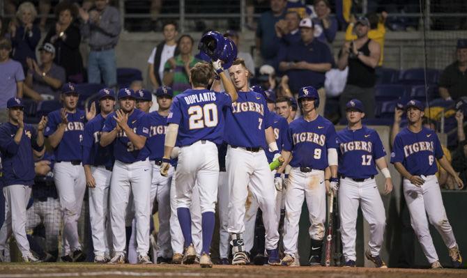 LSU sophomore outfielder Antoine Duplantis (20) hits helmets with junior infielder Greg Deichmann (7) after hitting a home run during the Tigers' 5-1 win against the University of Georgia on Saturday, March 18, 2017 at Alex Box Stadium.