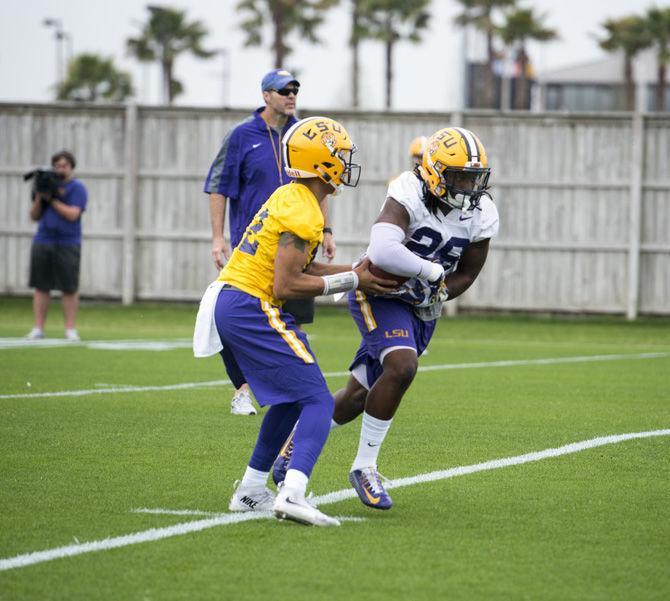 LSU redshirt sophomore quarterback Justin McMillan (12) hands the ball to senior running back Darrel Williams (28) during the first spring football practice on Saturday, March 11, 2017 at the Charles McClendon LSU football practice facility.