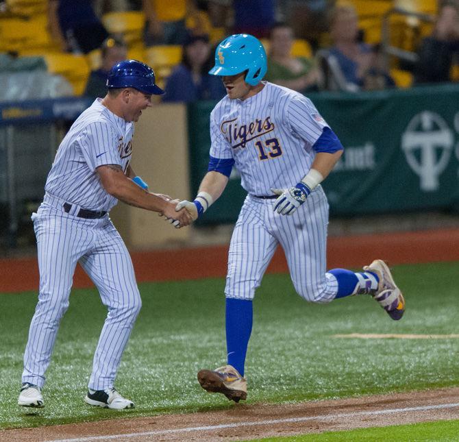 LSU assistant coach Seas Ochinko (left) celebrates with junior infielder and catcher Nick Coomes (13) (right) on Tuesday, April 18, 2017, during the Tigers&#8217; 10-4 victory over Lamar at Alex Box Stadium.