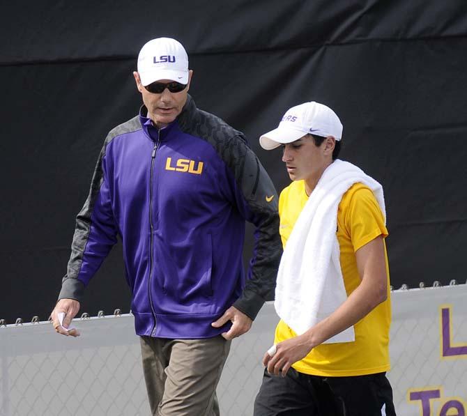 LSU men's tennis coach Jeff Brown (left) talks to freshman Justin Butsch (right) between games Friday, March 7, 2014 in W.T. "Dub" Robinson Stadium.