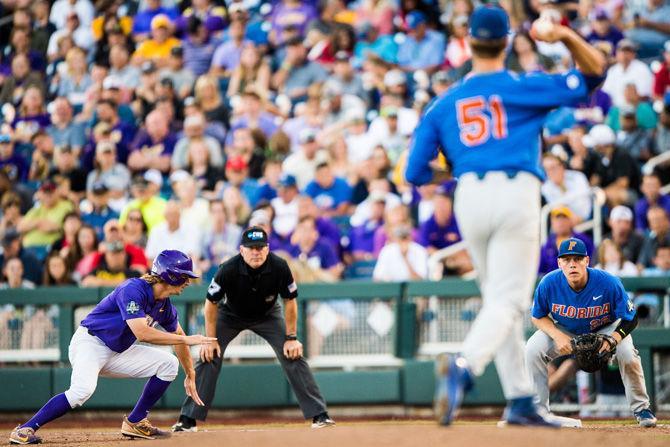 LSU freshman outfielder Zach Watson (9) begins to dive towards first base as Florida sophomore pitcher Brady Singer (51) throws the ball to first base during the Tigers' 4-3 loss against the Gators on Monday June 26, 2017, at TD Ameritrade Park in Omaha, Nebraska.