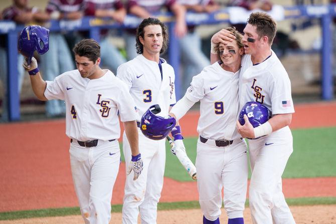 LSU freshman center fielder Zach Watson (9) celebrates at home plate with freshman third basemen Josh Smith (4), senior short stop Kramer Robertson (3) and junior catcher Michael Papierski (2) after scoring during Friday's game against Texas Southern on June 2, 2017, in Alex Box Stadium.