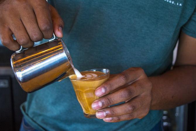 A barista at French Truck Coffee pours steamed milk into a latte on Friday, Aug. 18, 2017.