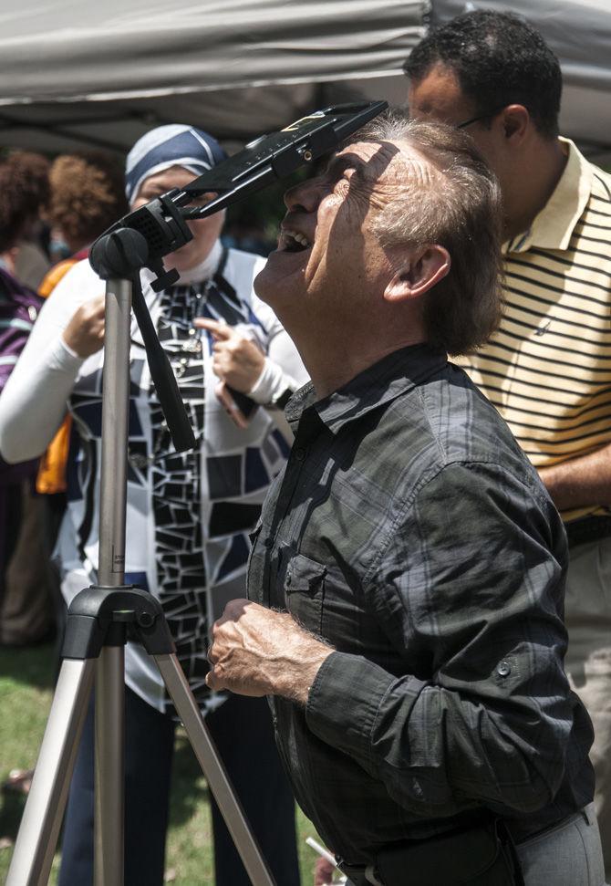 Onlookers observe the eclipse with equipment provided by CxC at the Parade Ground on Aug. 21, 2017.