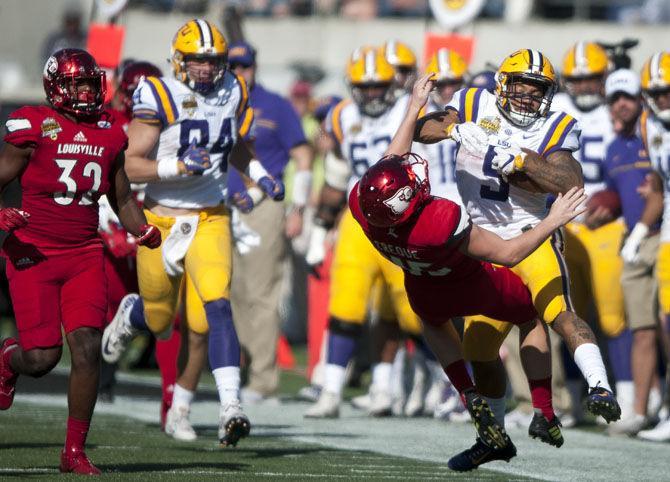 LSU sophomore running back Derrius Guice (5) counters Louisville sophomore kicker Blanton Creque's (45) attempted tackle on Saturday, Dec. 31, 2016, during the Tigers' 29-9 Buffalo Wild Wings Citrus Bowl win against the Cardinals at Camping World Stadium in Florida.